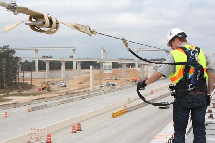 Worker securing fall lanyard connection