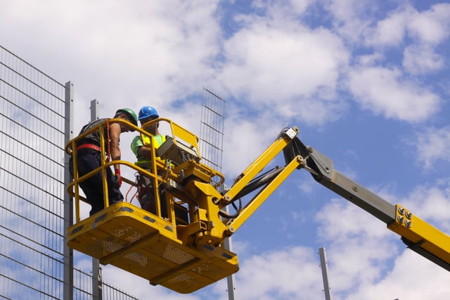 two construction workers in aerial lift